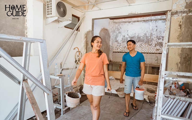 Couple walking with bucket of cement for renovation